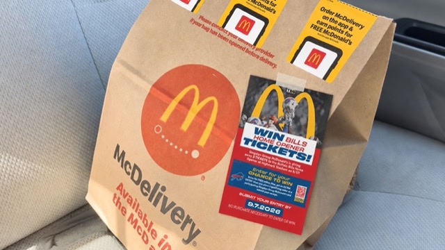 A Win Bills Home Opener Tickets bag stuffer taped to a McDelivery bag on a car seat