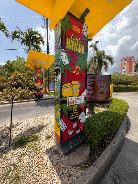 A drive-thru pillar wrapped in Little Havana artwork with dominoes and congas