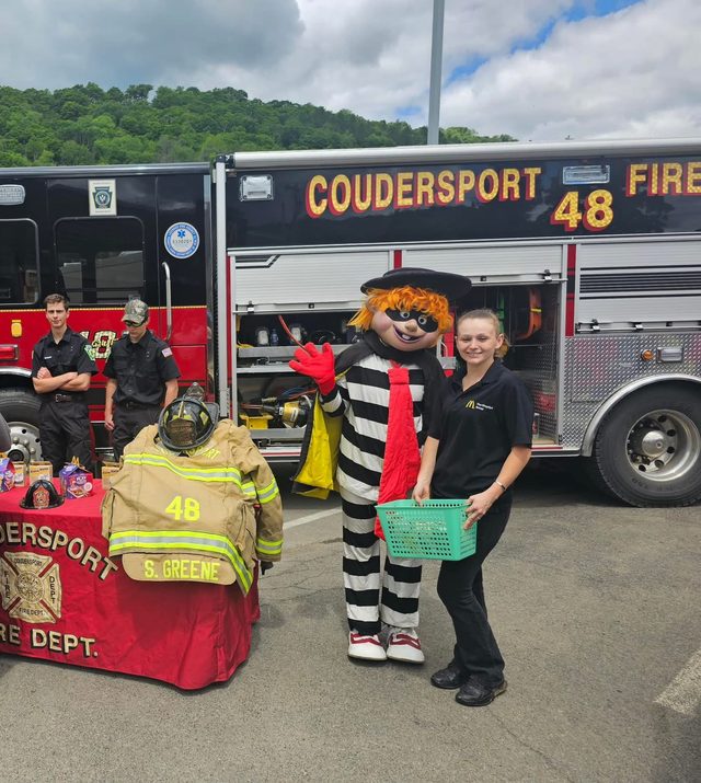 Hamburglar and a Singelyn Group crew member in front of the Coudersport Fire Department truck at the Happy Meals with a Hero event